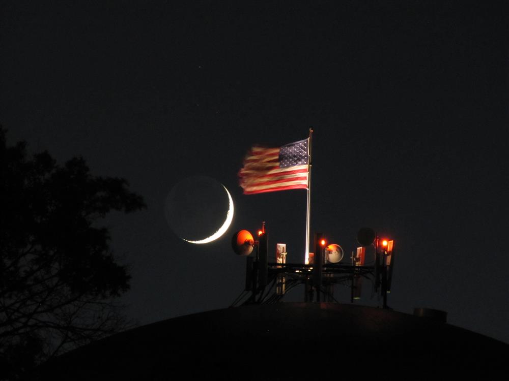 Crescent moon setting over the flag Sky & Telescope