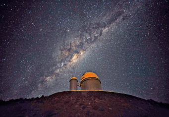 The ESO 3.6-metre telescope at La Silla, during observations. Across the plan of the picture, is the Milky Way, our own galaxy, a disk-shaped structure seen perfectly edge-on.