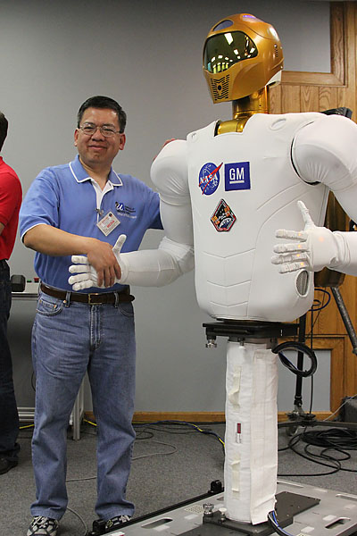 Edwin Aguirre shakes hands with Robonaut 2